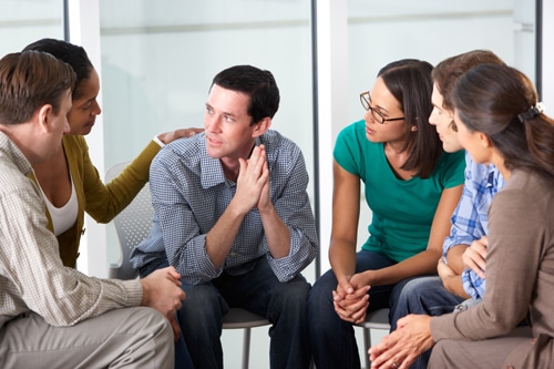 Young women comforting a man during addiction And spirituality group session